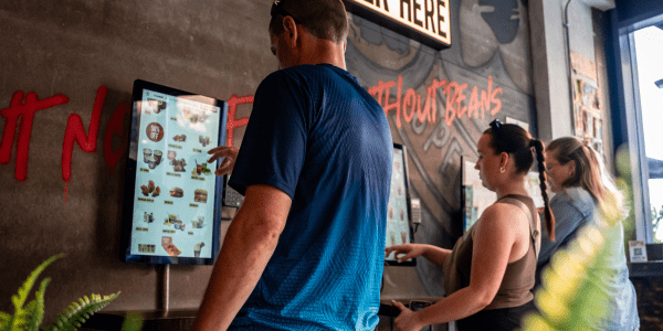 Customers using kiosks in a Black Sheep Coffee