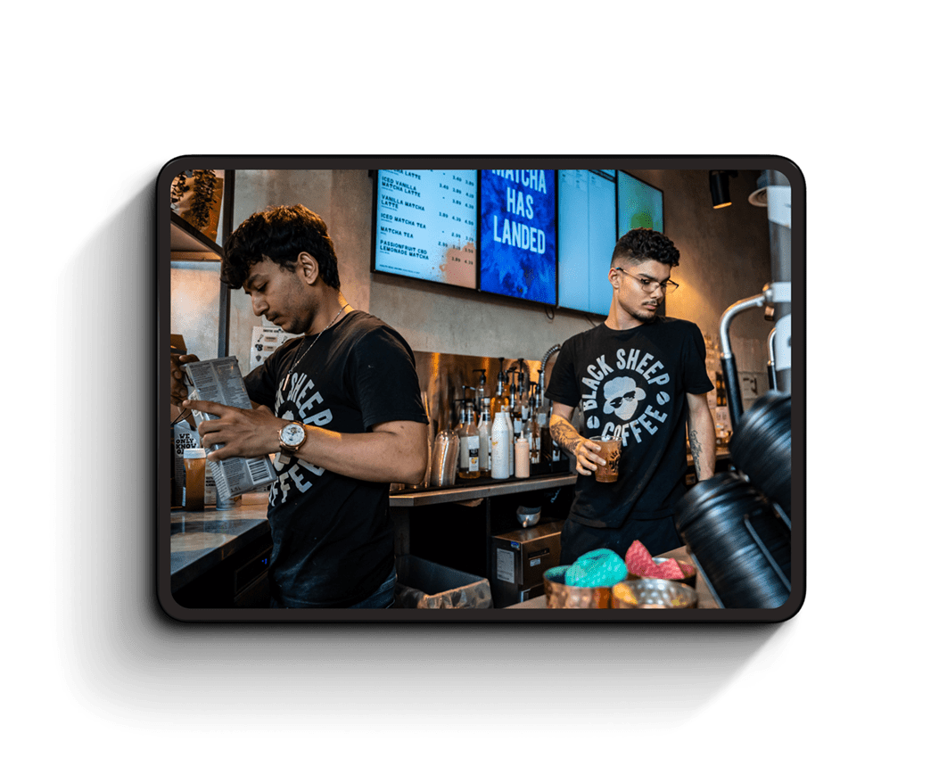 Two people working behind the counter at black sheep coffee