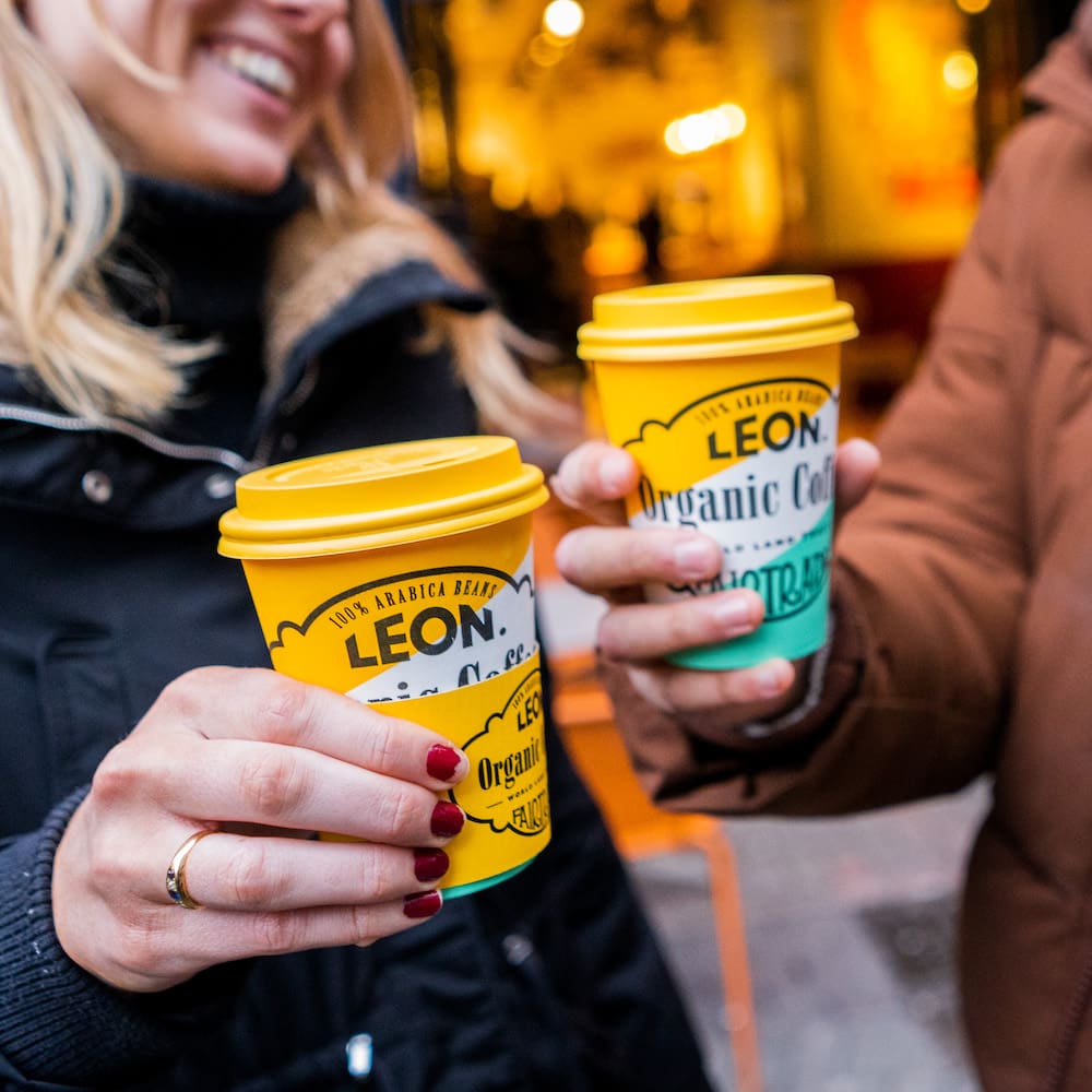 two people holding coffees from Leon